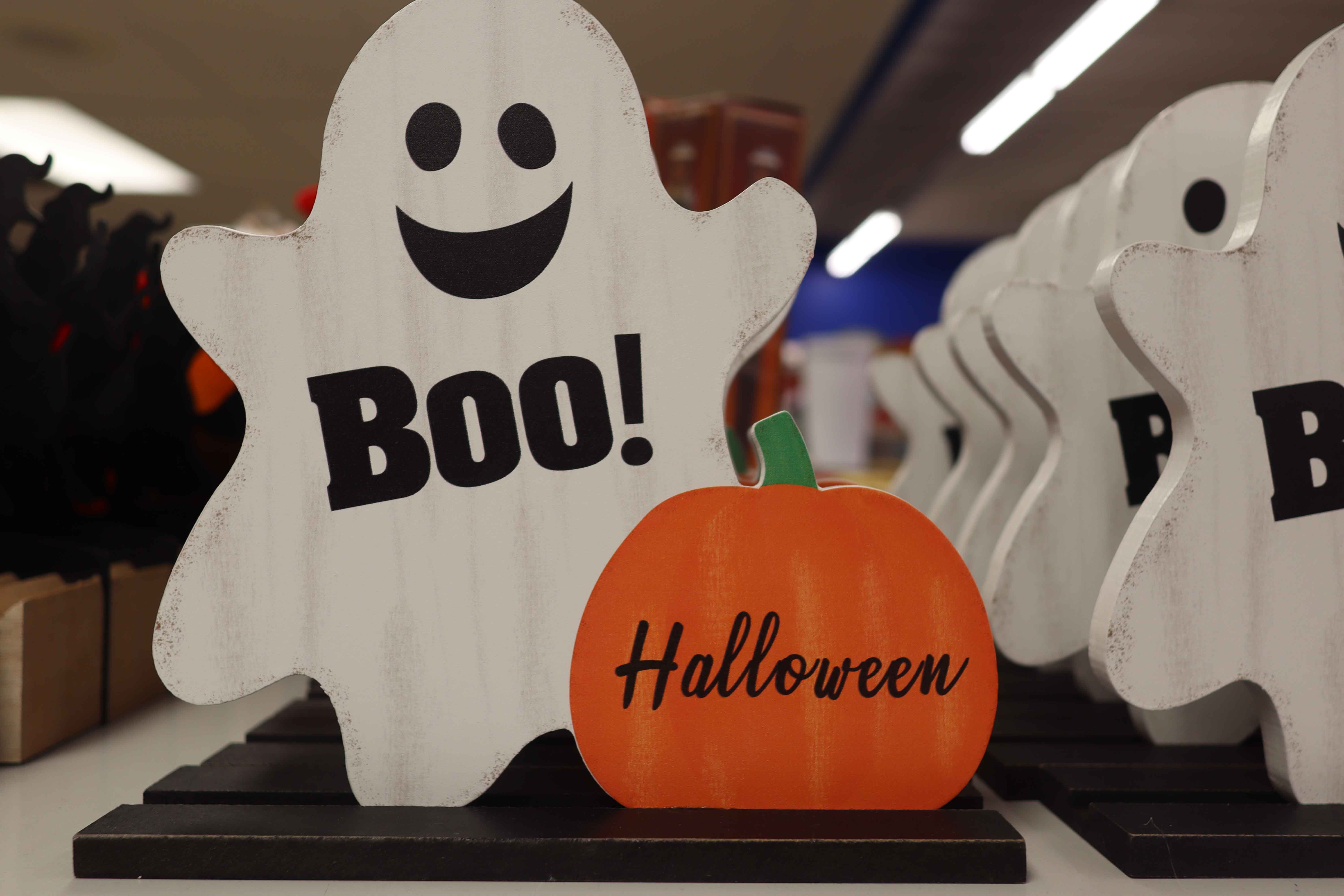 Ghost and pumpkin decoration stating "Halloween".